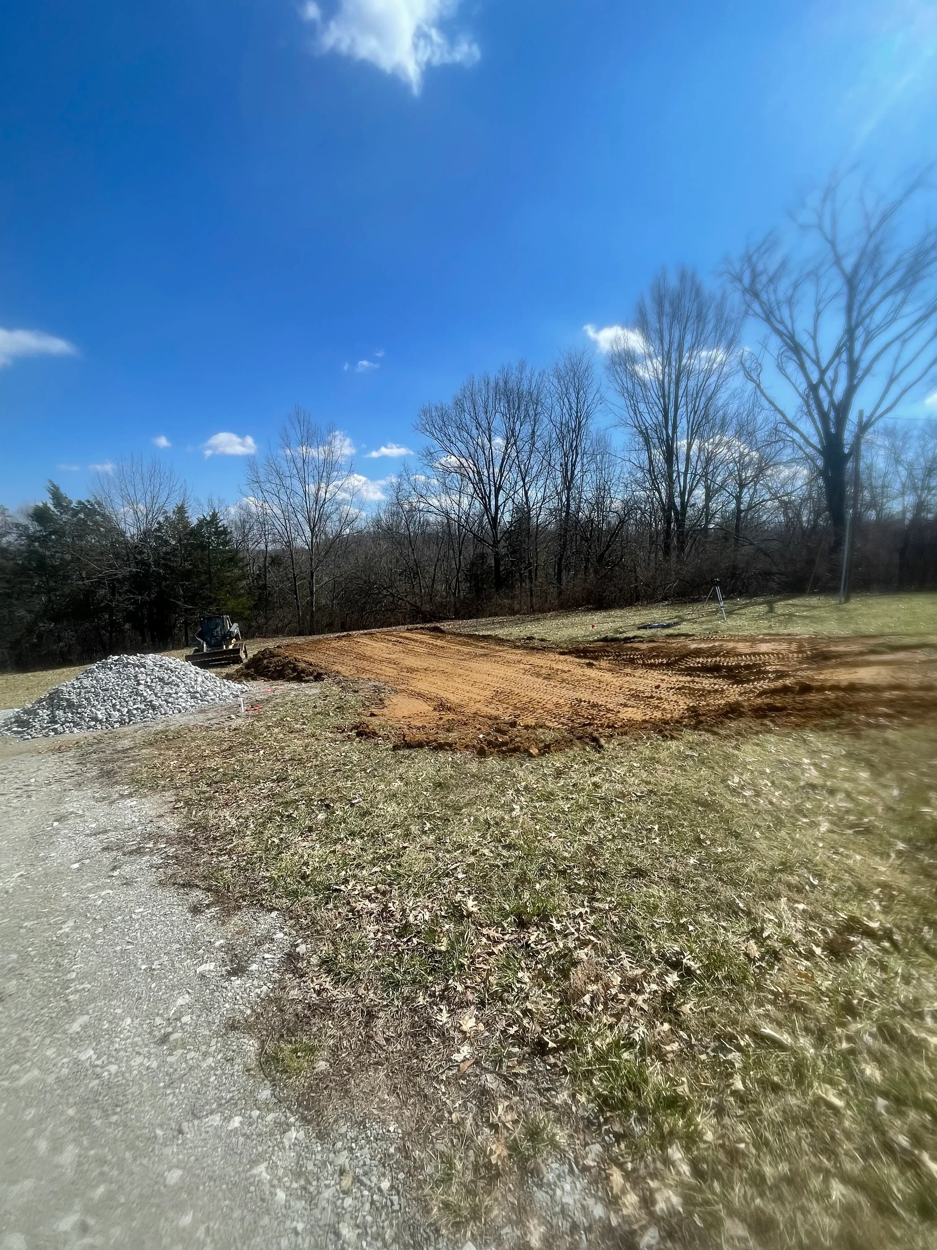 Gravel driveway base with compacted stone aggregate and cleared earthwork